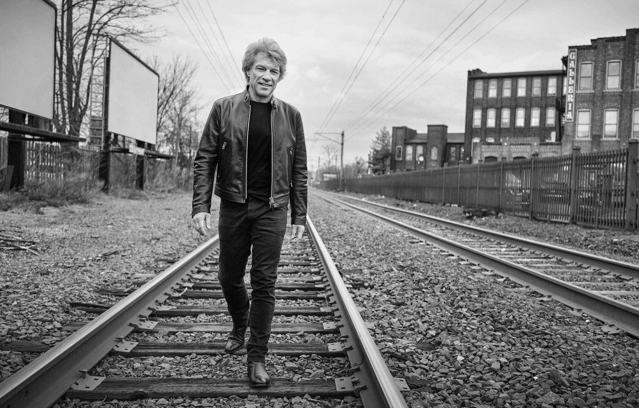 Jon Bon Jovi walking on railroad tracks