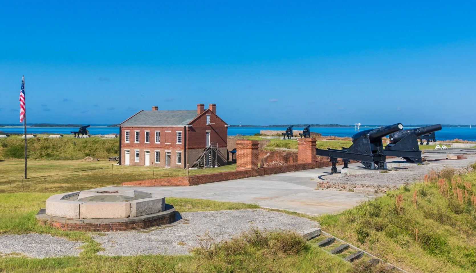 Nostalgic Beach Getaways cannons near a building overlooking the ocean
