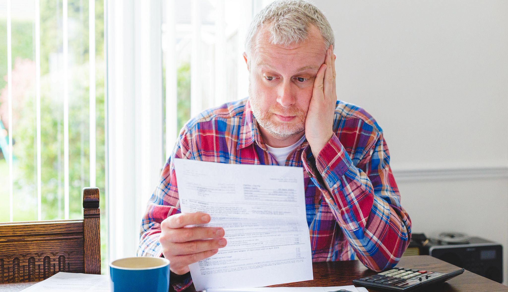 Worried man checking energy bills at home
