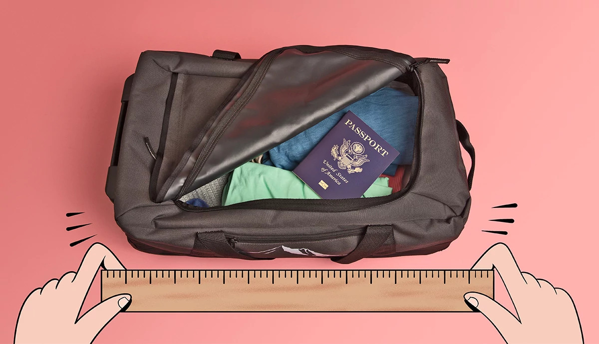 Hands hold a ruler and measure a duffel bag filled with clothes and a passport.