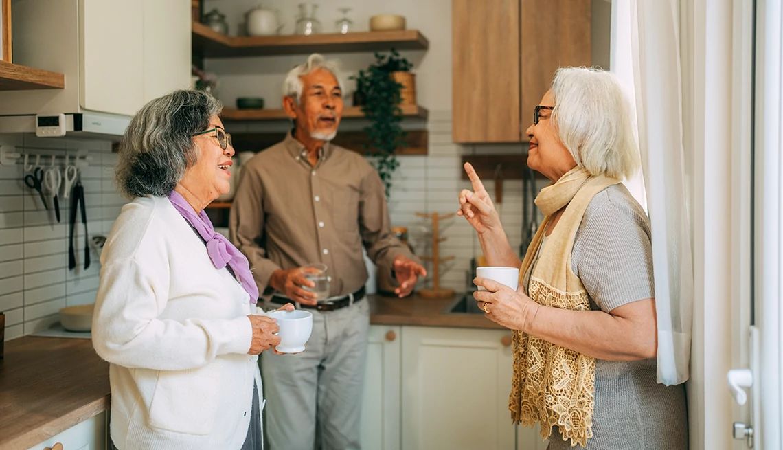 Old Friends Clash With New Love A group of older adult friends engage in a spirited discussion in the kitchen.
