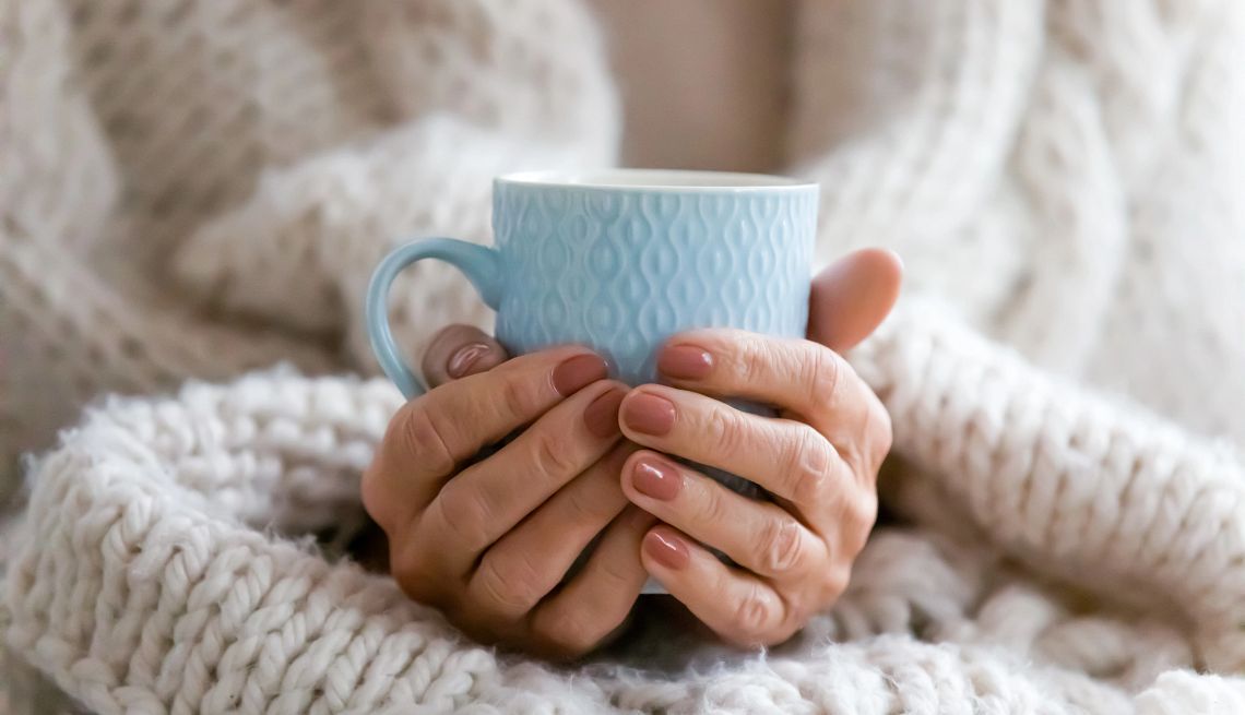 hands wrapped around a coffee mug hands wrapped around a coffee mug