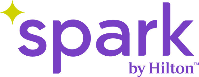 Spark by Hilton logo in purple with gold star-like symbol in left corner of logo