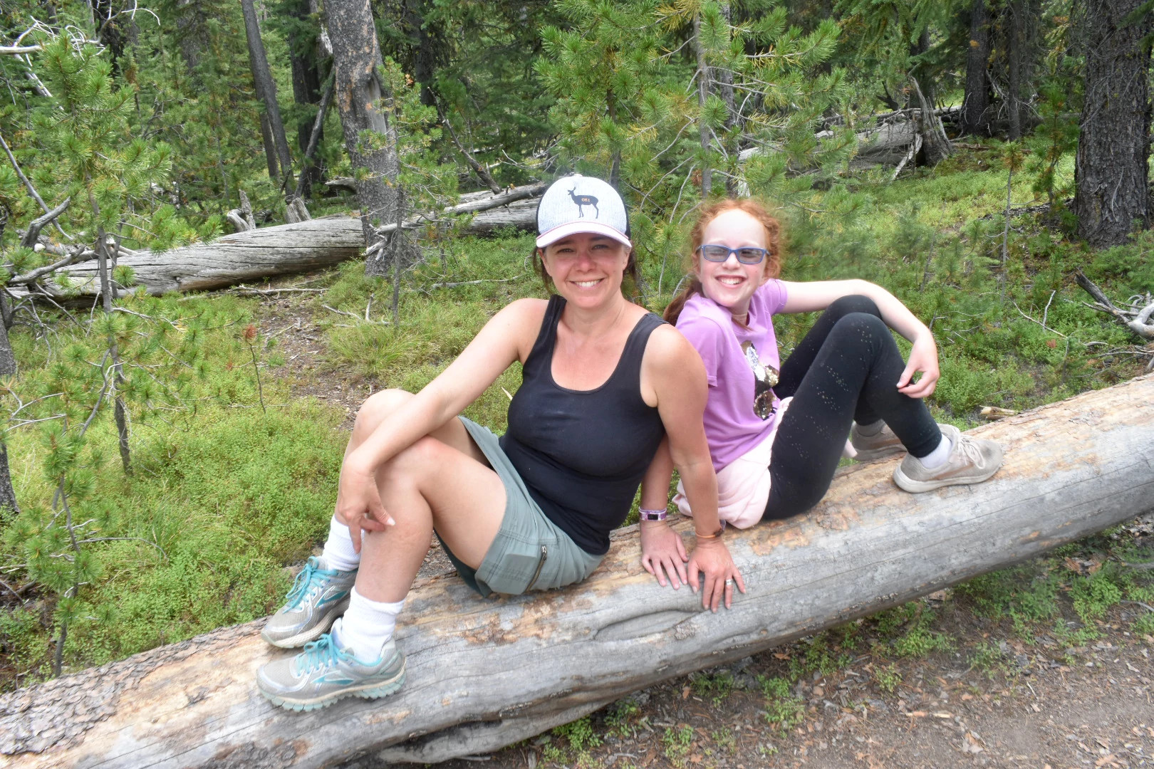 photo of author and her daughter outside hiking sitting on a log