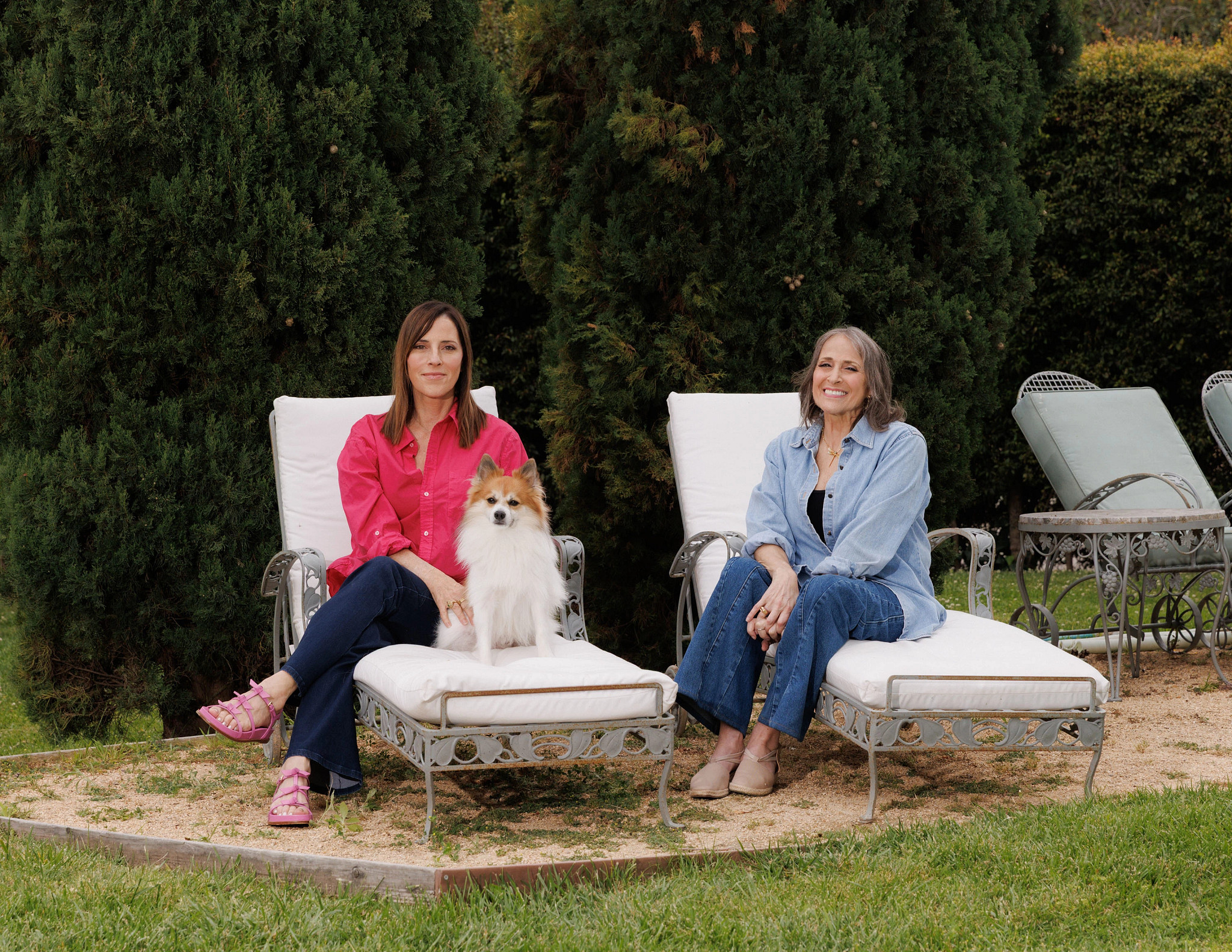 a photo shows Cecilia Peck with her dog Ringo visiting with Janna Gelfand on cushioned outdoor chairs