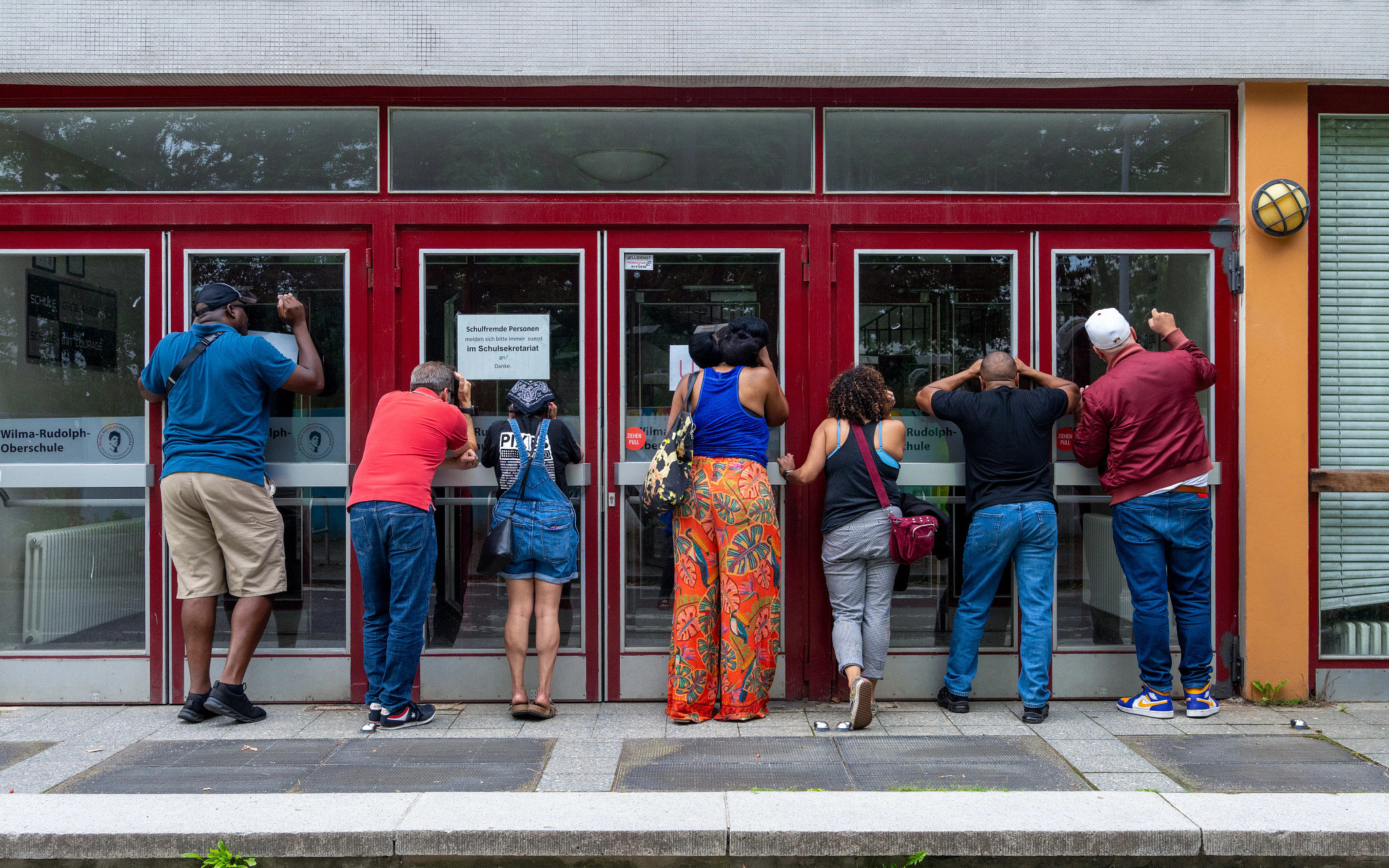 7 people looking through doors, german school, high school reunion