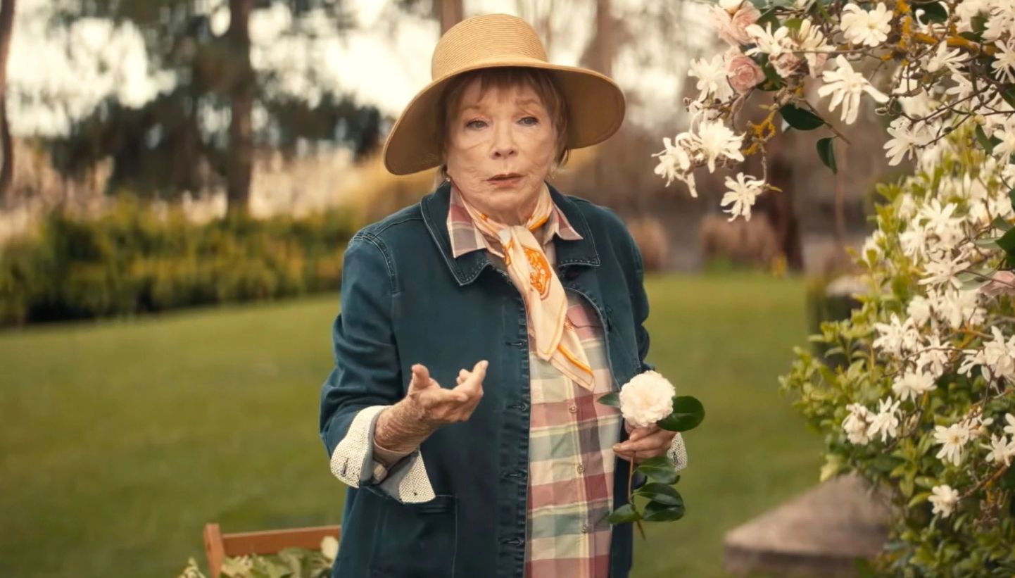 Shirley MacLaine standing in a garden in a scene from American Dreamer