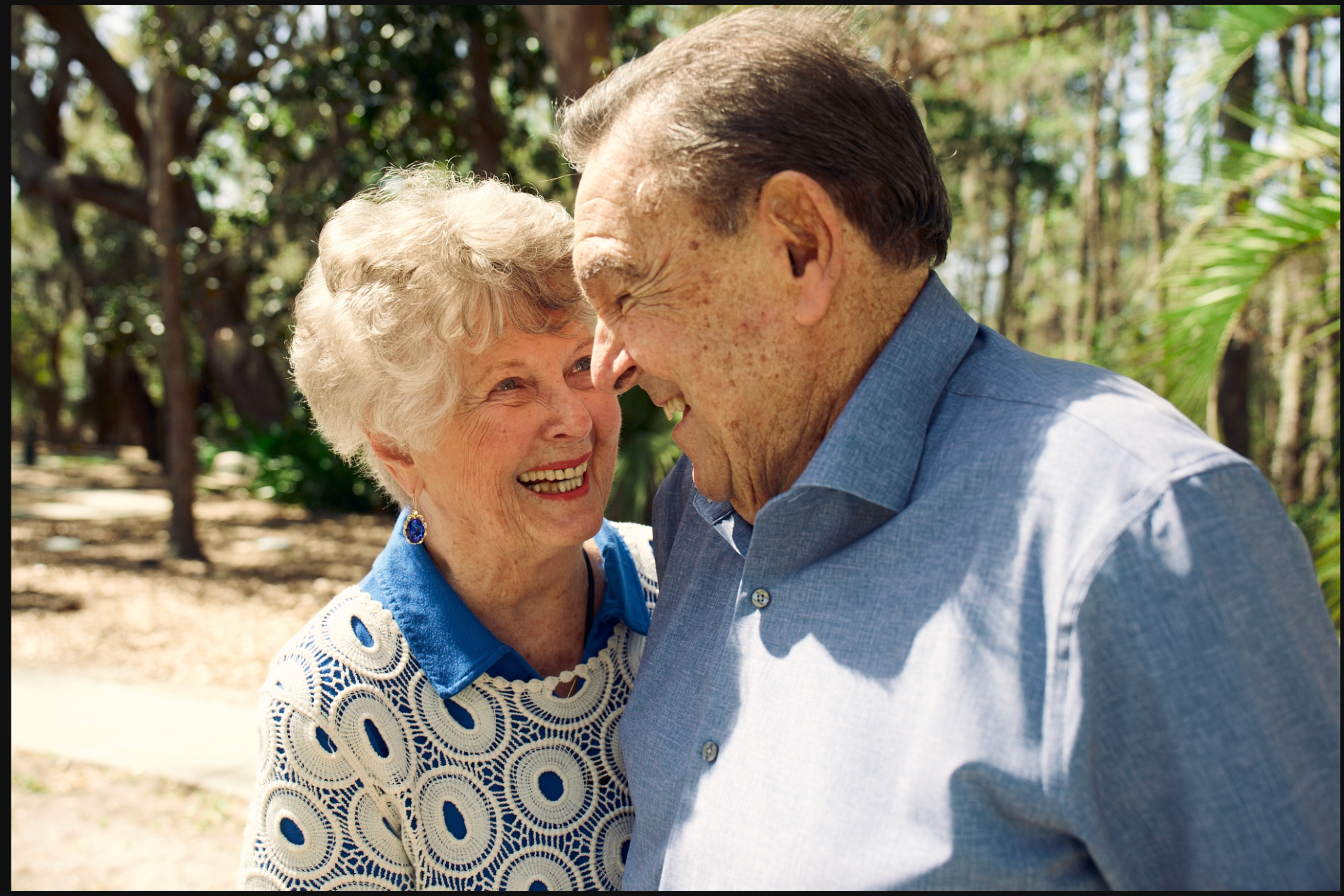 primer plano de un hombre y una mujer mayores sonriéndose el uno al otro