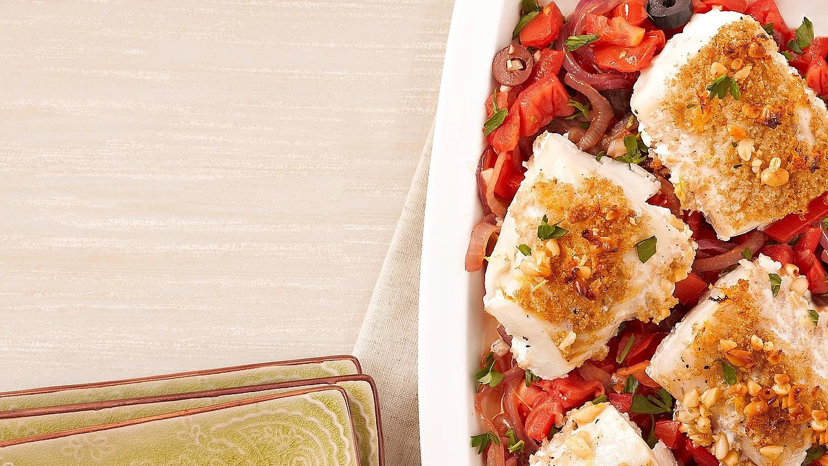 A close-up view of nut-crusted cod with caramelized onions