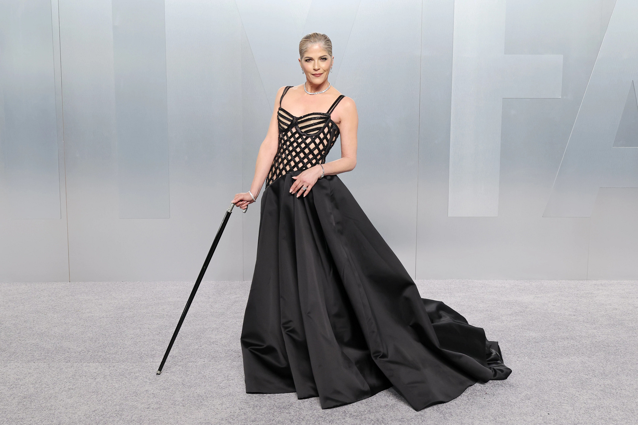 selma blair posing for a portrait in a dramatic black gown, holding a cane