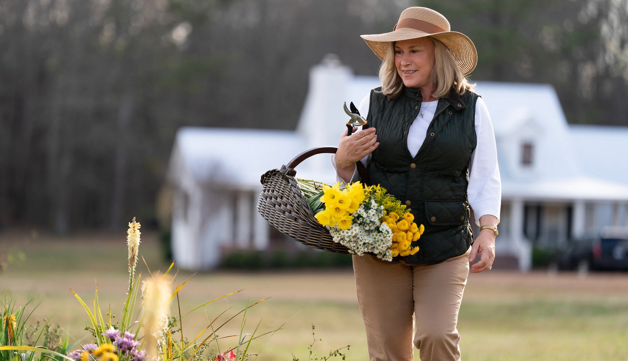 Best Things Coming to Hulu a woman carrying a basket of flowers and pruning shears outdoors in a scene from murdaugh death in the family