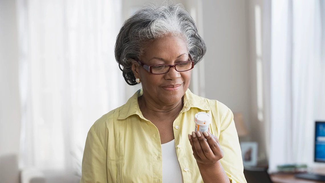 CVS Pharmacy Mature African American woman holding prescription bottle