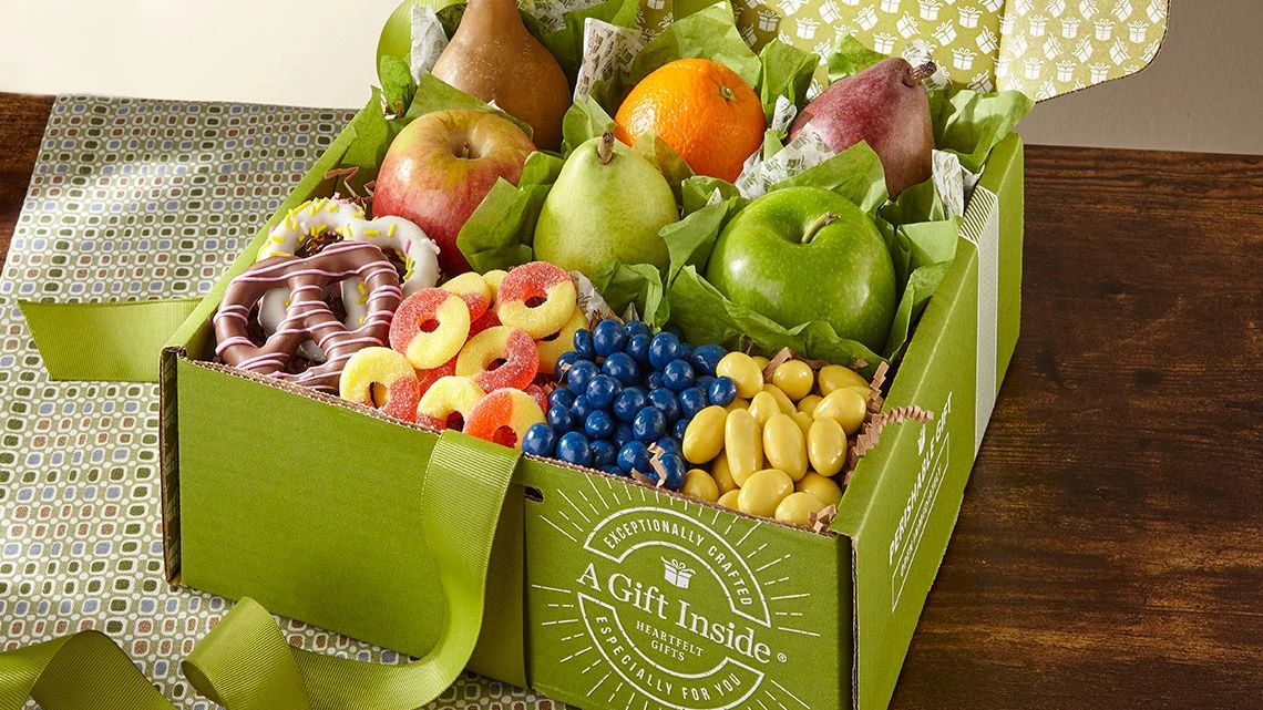 Food & Gifts by FTD green gift box of chocolate covered pretzels, gummy circles, candy coated berries, nuts, pears, apples, oranges