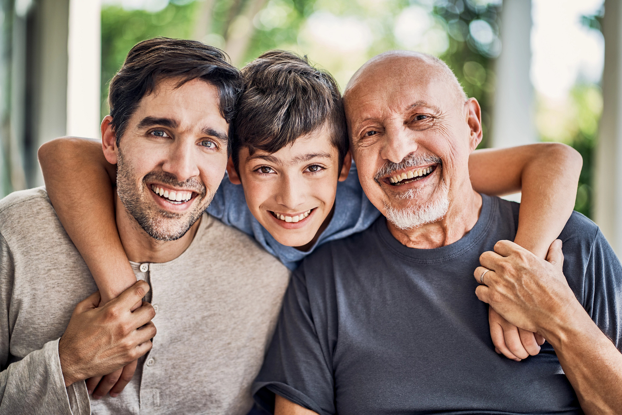 Close-up portrait of smiling multi-generation family. Happy males are relaxing at patio. They are wearing casual clothing