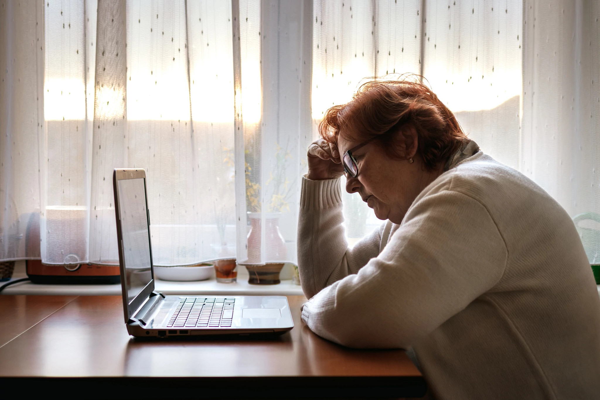 Worried senior woman browsing bad news at internet. Old people reading online news