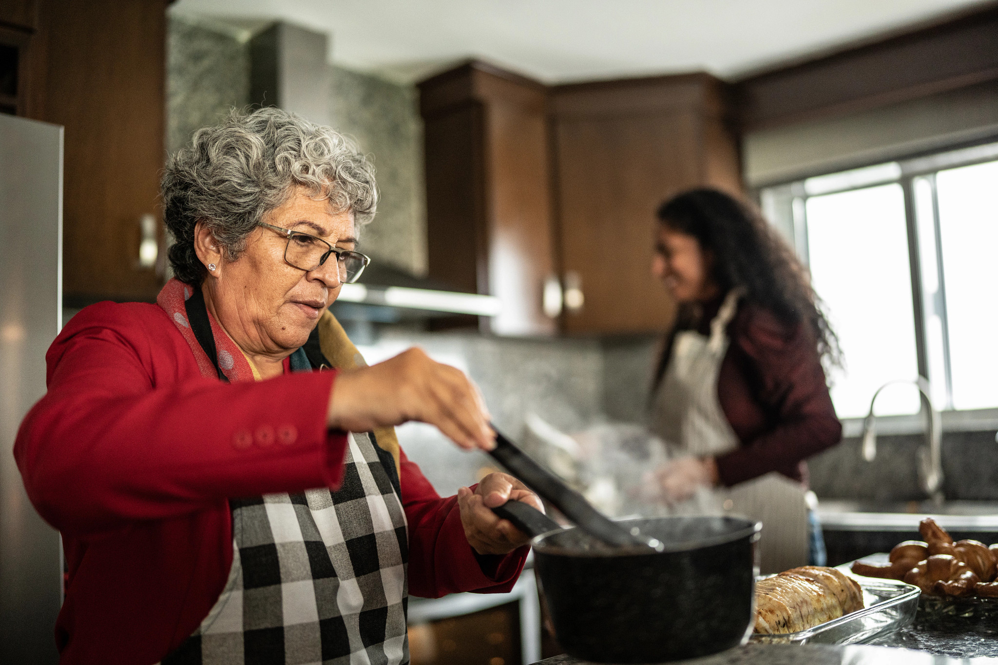 Hispanic woman preparing food at kitchen counter at home.