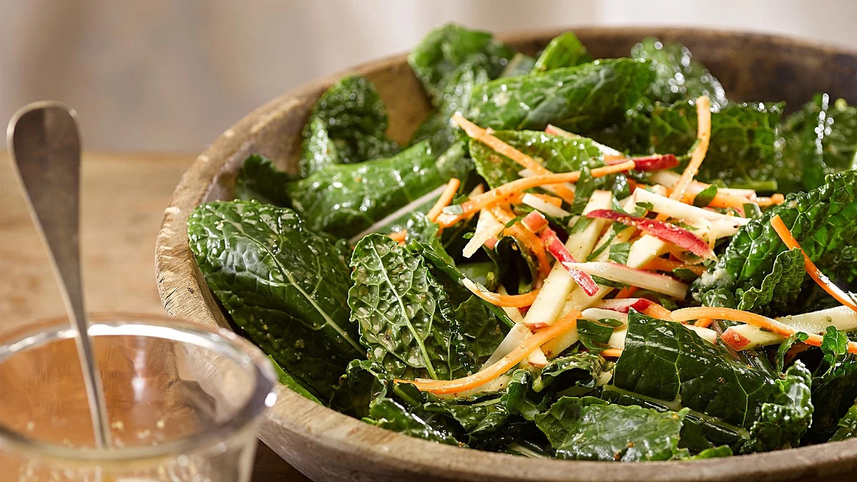 A close-up view of kale, carrot and apple salad
