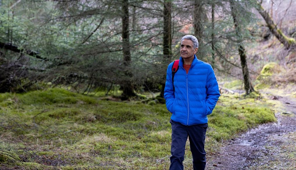 Walking may help bring you awareness to the present moment and relax A man walking through a wooded area