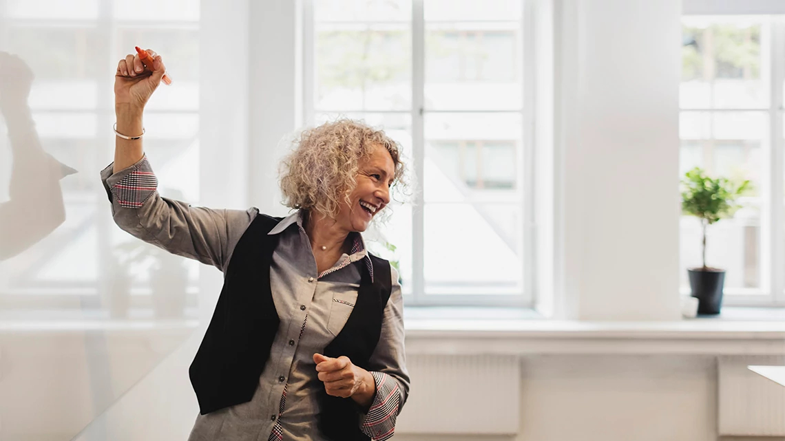 AARP Driver Safety Smiling teacher writing on whiteboard