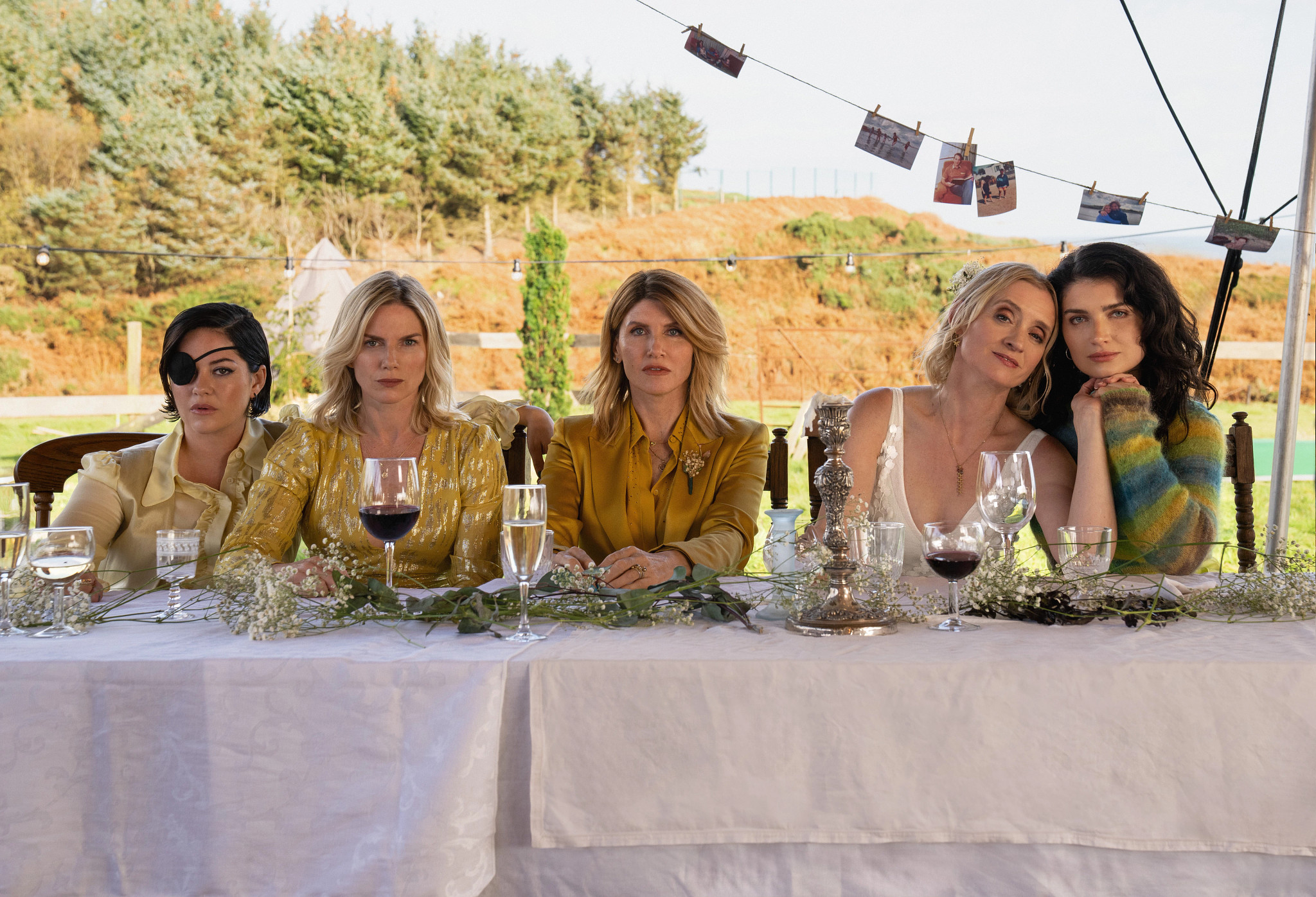 Sarah Greene, Eva Birthistle, Sharon Horgan, Anne-Marie Duff and Eve Hewson sitting together at a table in the Apple TV Plus series Bad Sisters