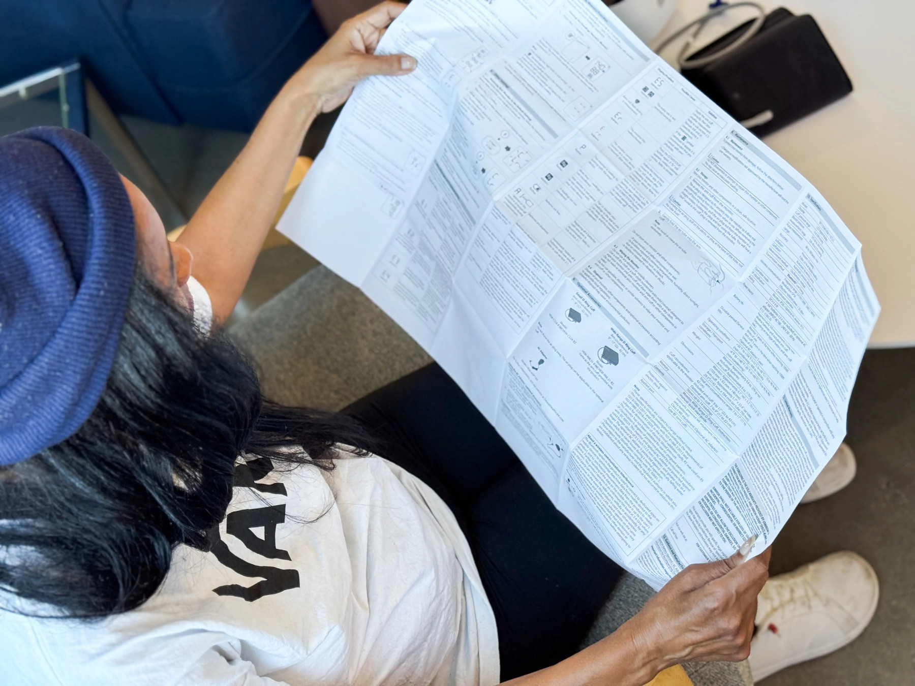  A woman reading the instructions of the Omron 3 Series blood pressure monitor.