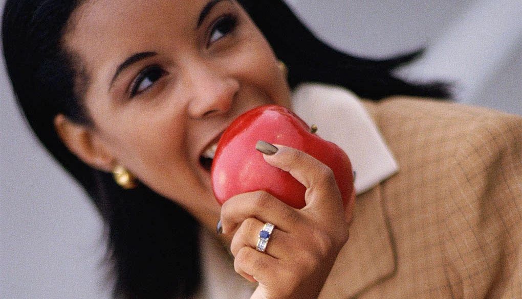 Fruits and vegetables can support brain function A woman taking a bite into an apple