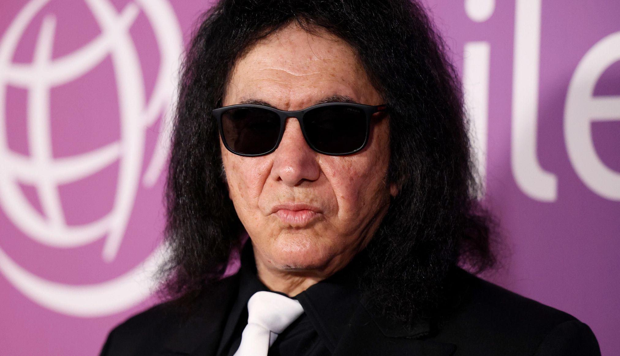 Gene Simmons Involved in Car Crash Gene Simmons in a black jacket, white tie and sunglasses