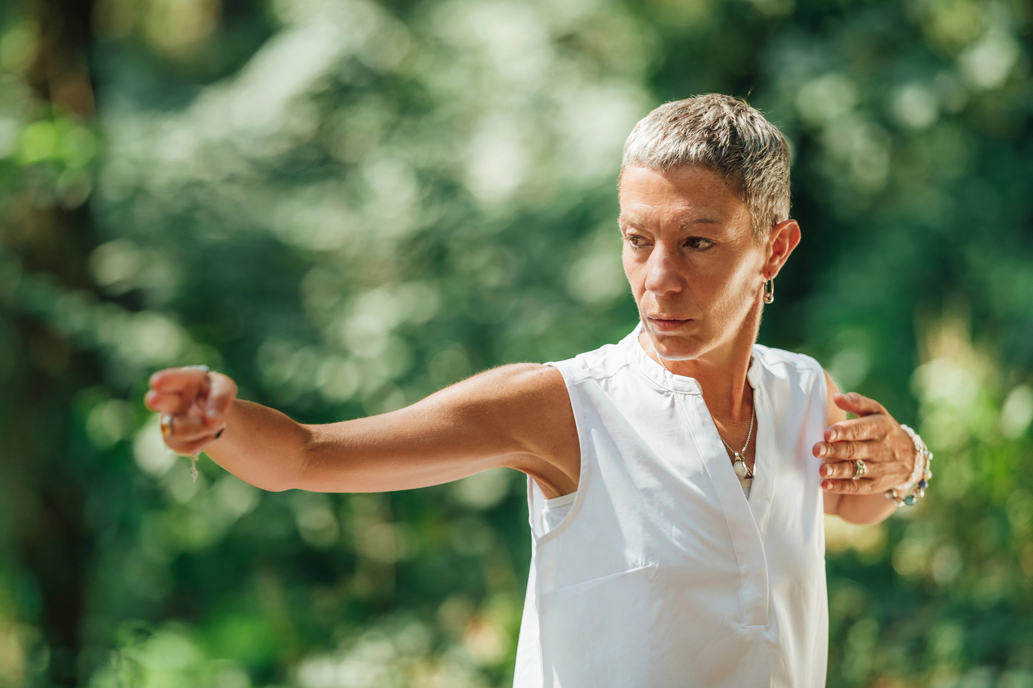 Woman practicing qigong in a forest