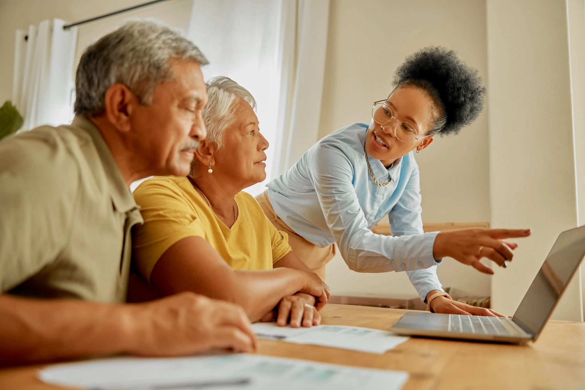 Laptop, discussion and financial advisor with a senior couple talking on pension, retirement fund or savings. Technology, planning and accountant with elderly people for finance management at home.