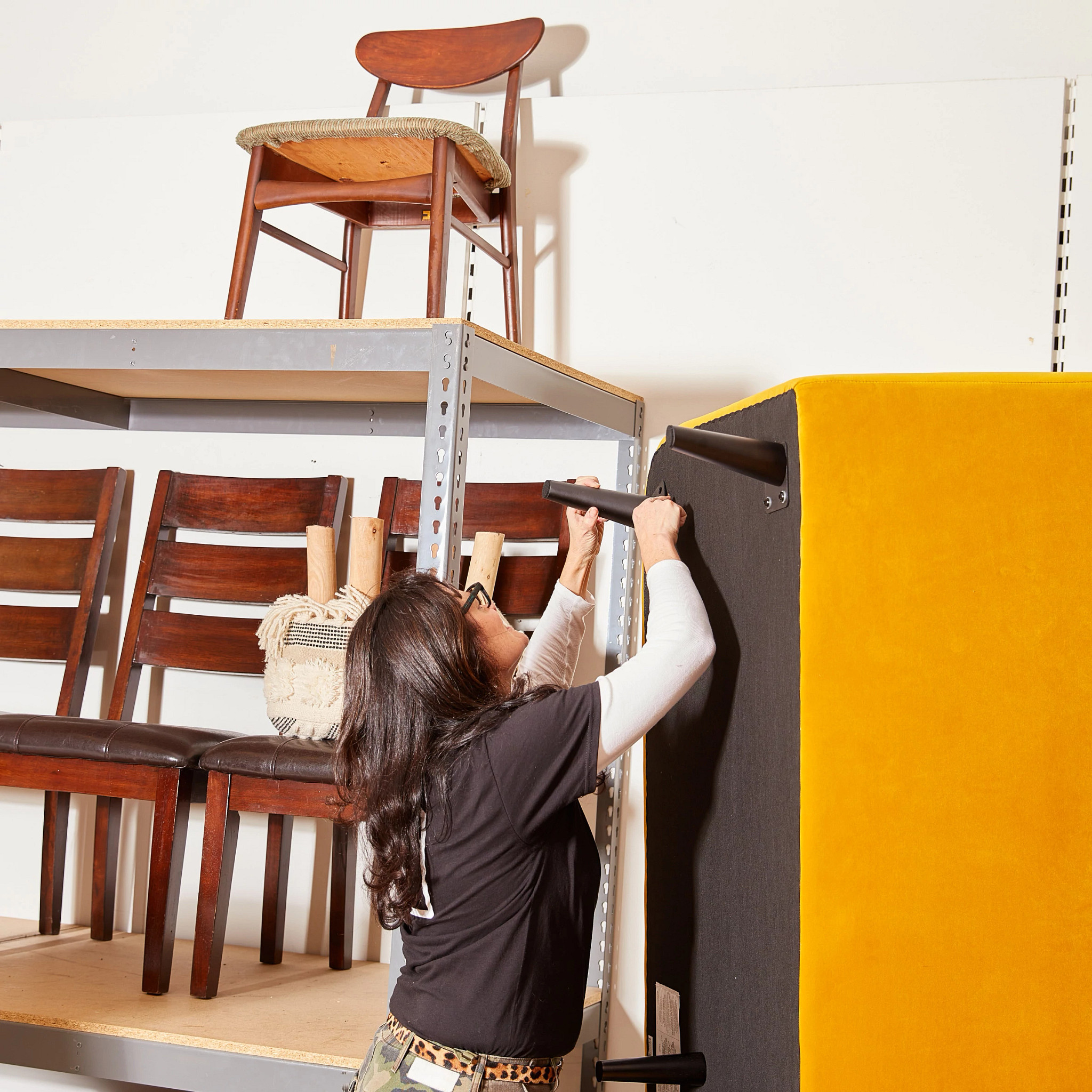 A photo shows Carolyn Flannery fixing a sofa. Flannery started a nonprofit to help foster kids aging out of the system get set up with furniture