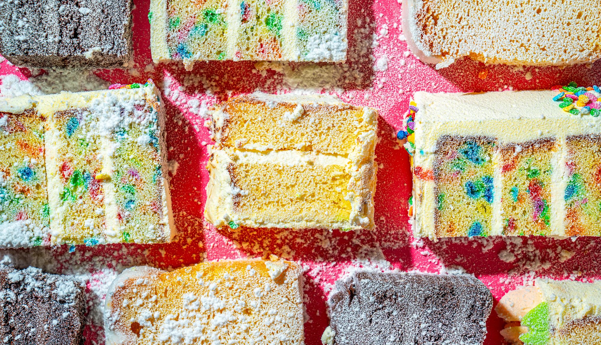 an assortment of cake on a pink background