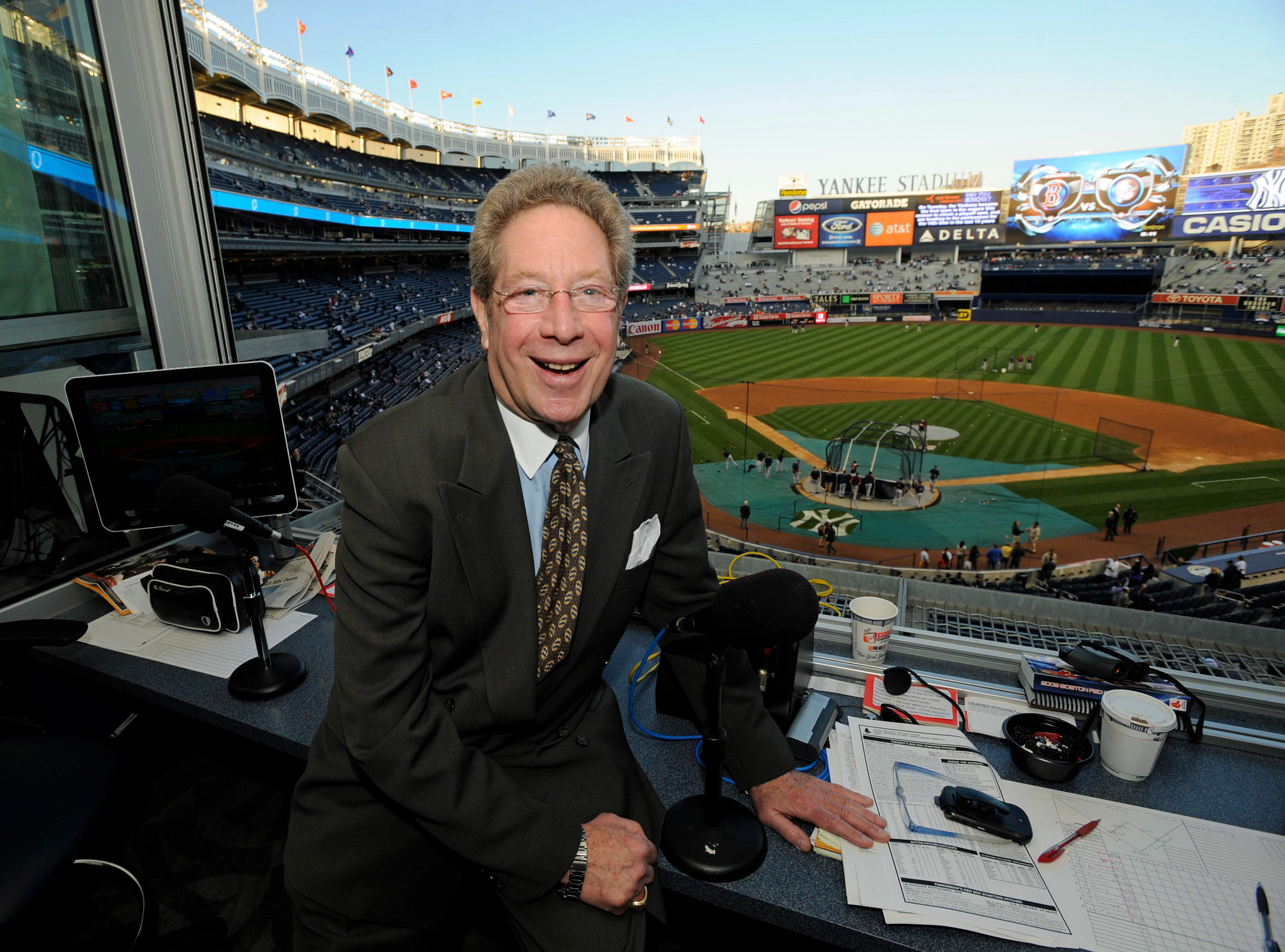 john sterling in a suit with yankee stadium in the background