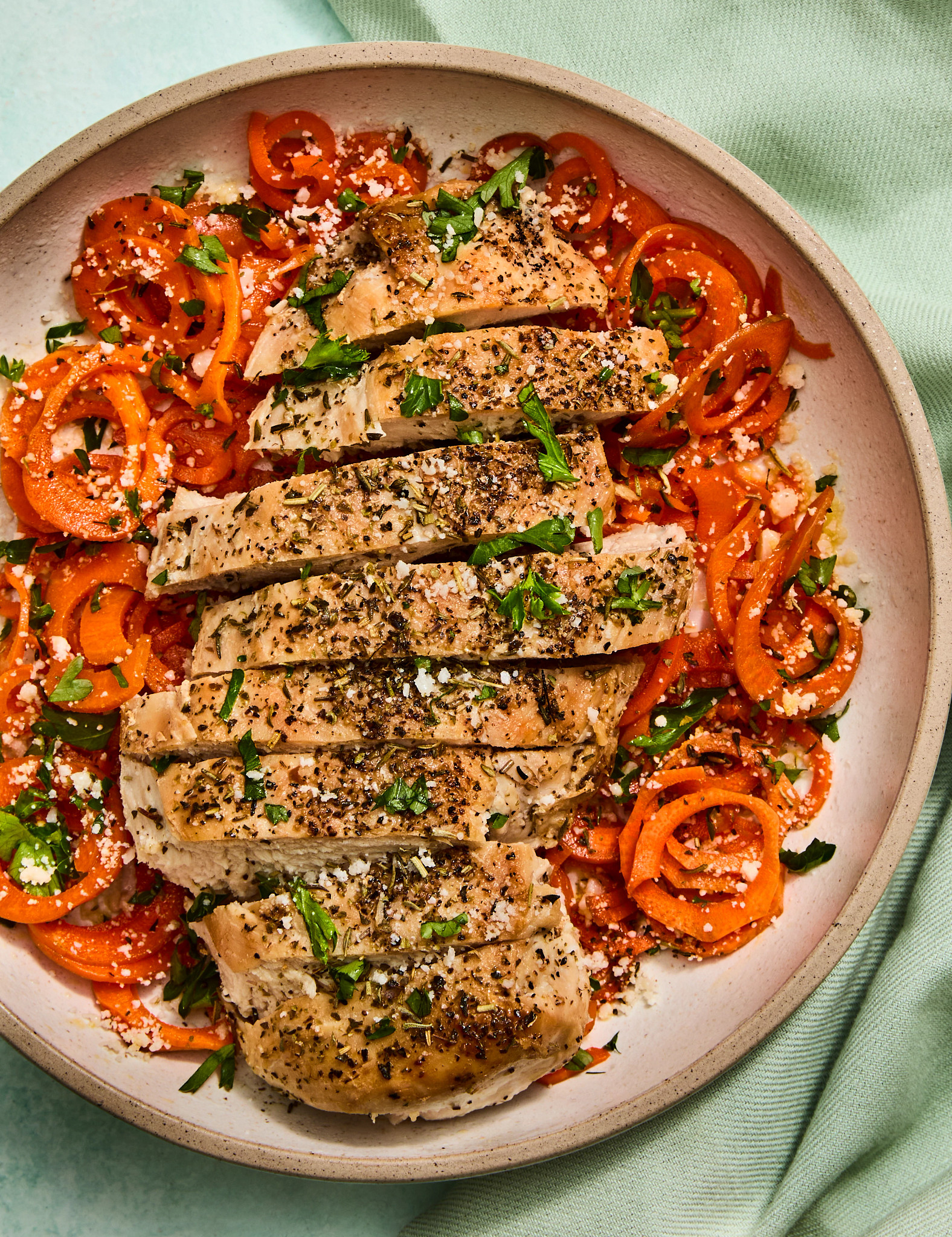 carrot spiral bowls with garlic parmesan chicken are shown in a photo