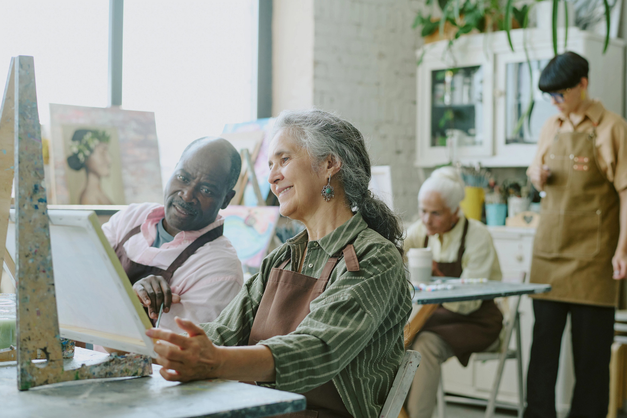  Lovely biracial senior couple admiring painting together during art therapy attendance