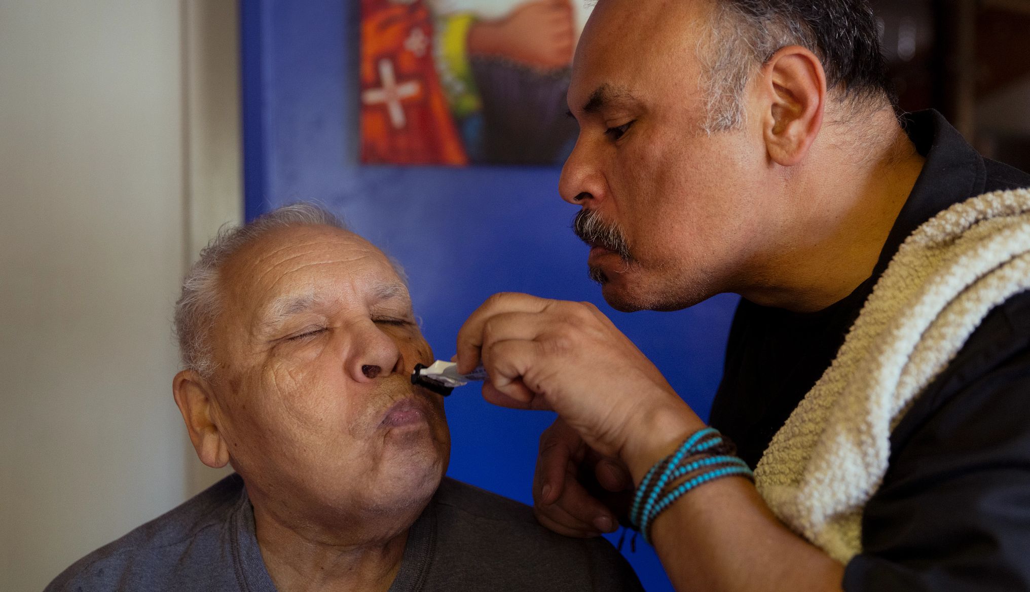 Carlos Luis Olivas III shaves his father's face at home