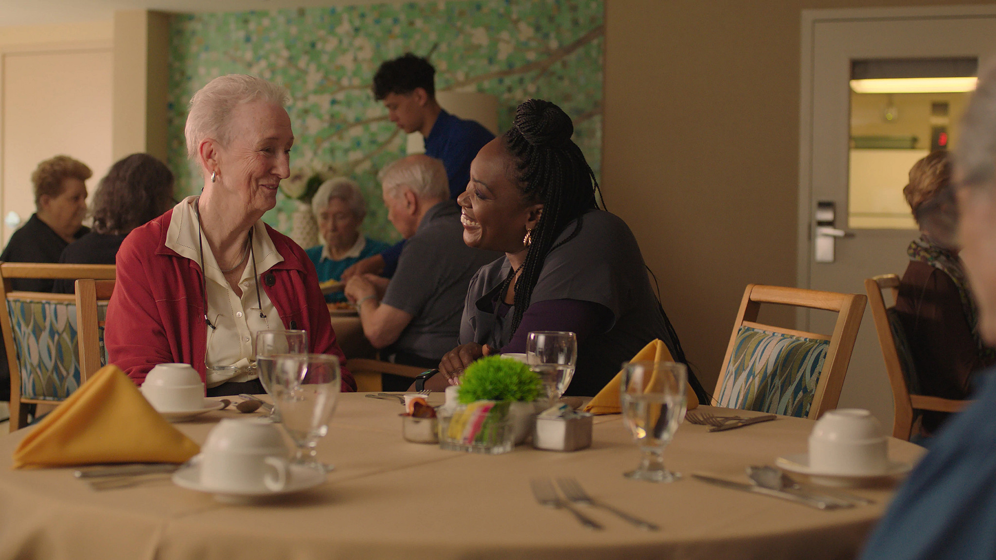 two people sitting and talking at a table