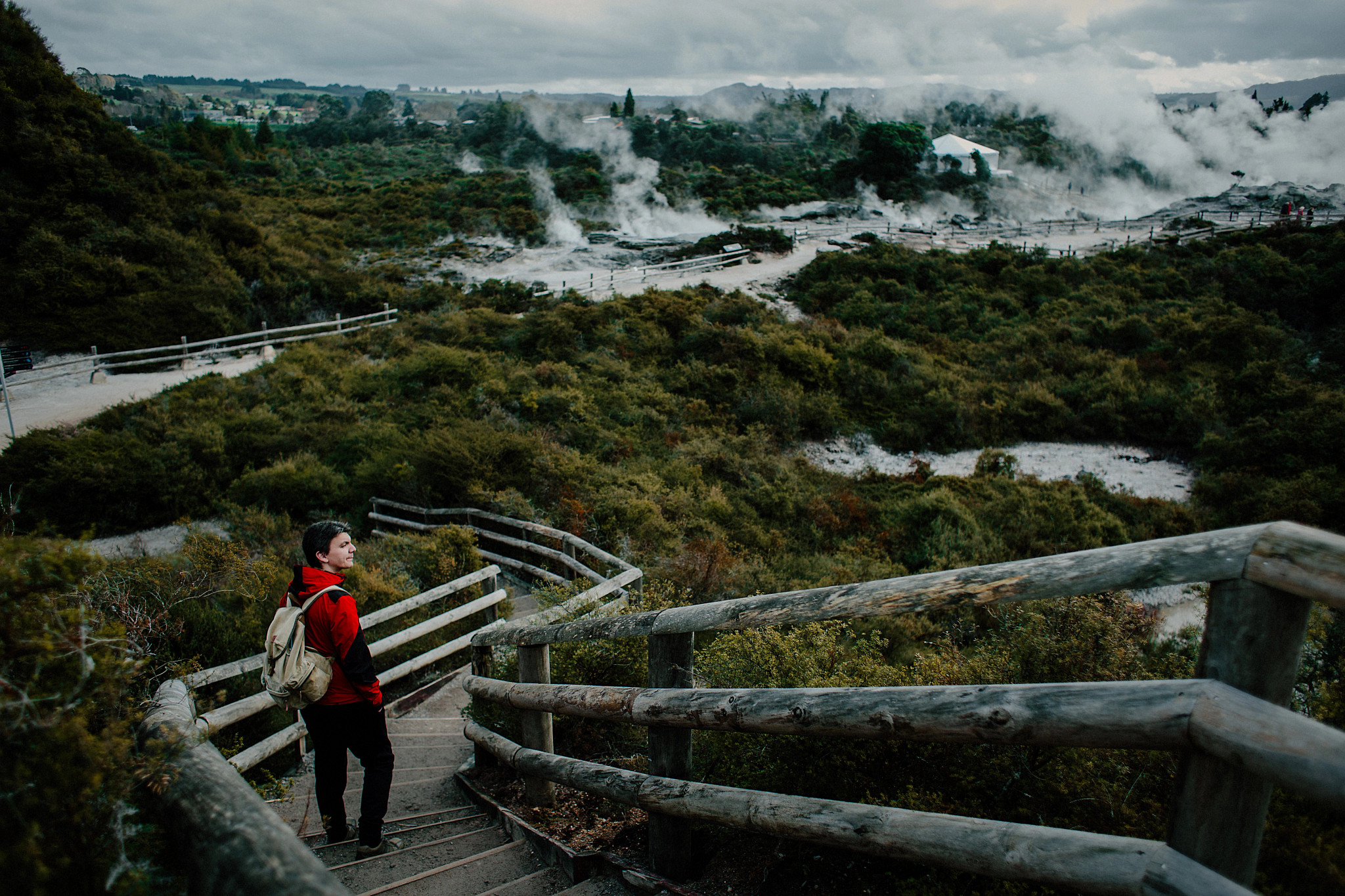 Una persona camina por un sendero en una zona boscosa cerca de unas aguas termales.