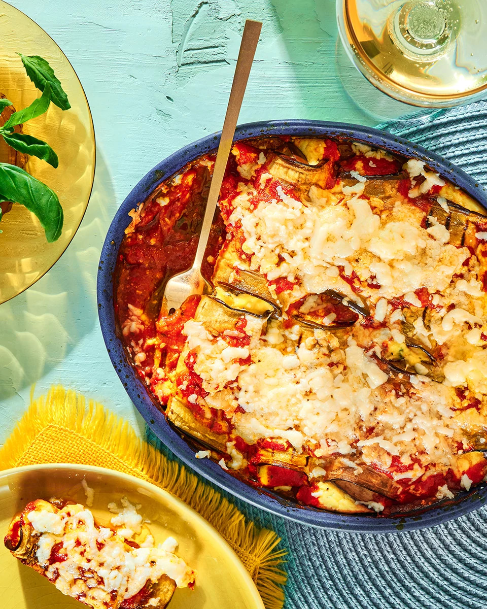 Cheesy eggplant parmesan bubbling in a blue cast-iron skillet