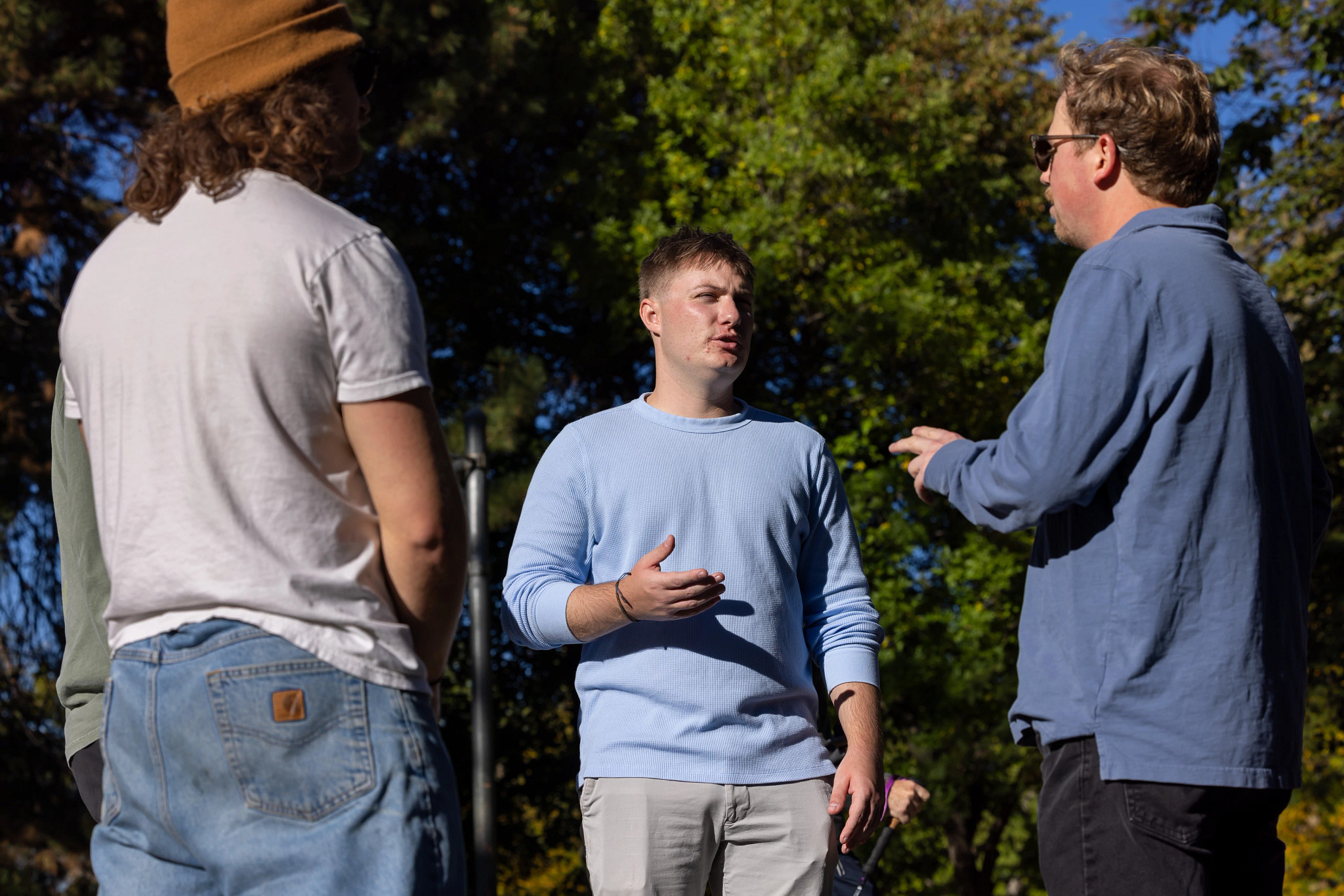 Evan Clark and friends talk outside at a park.