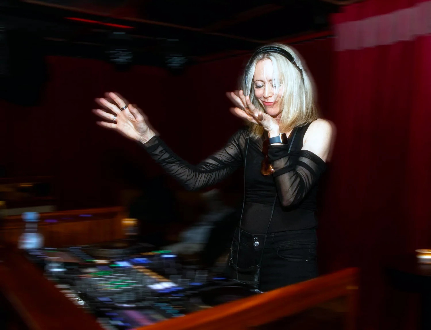 Tina Woods flowing to the music behind the DJ booth at a club