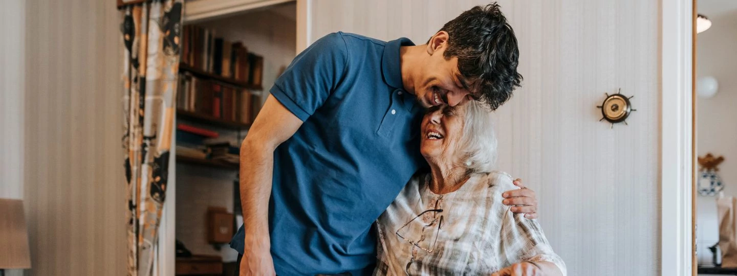 A son and his mother share a laugh together at home.
