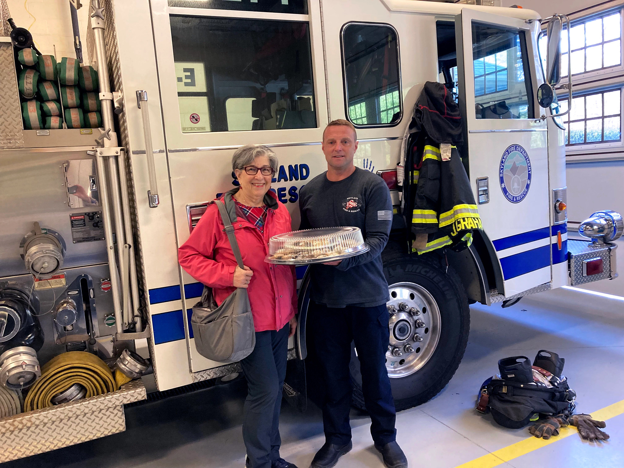 Barbara Beckerman gives extra baked goods to a firefighter