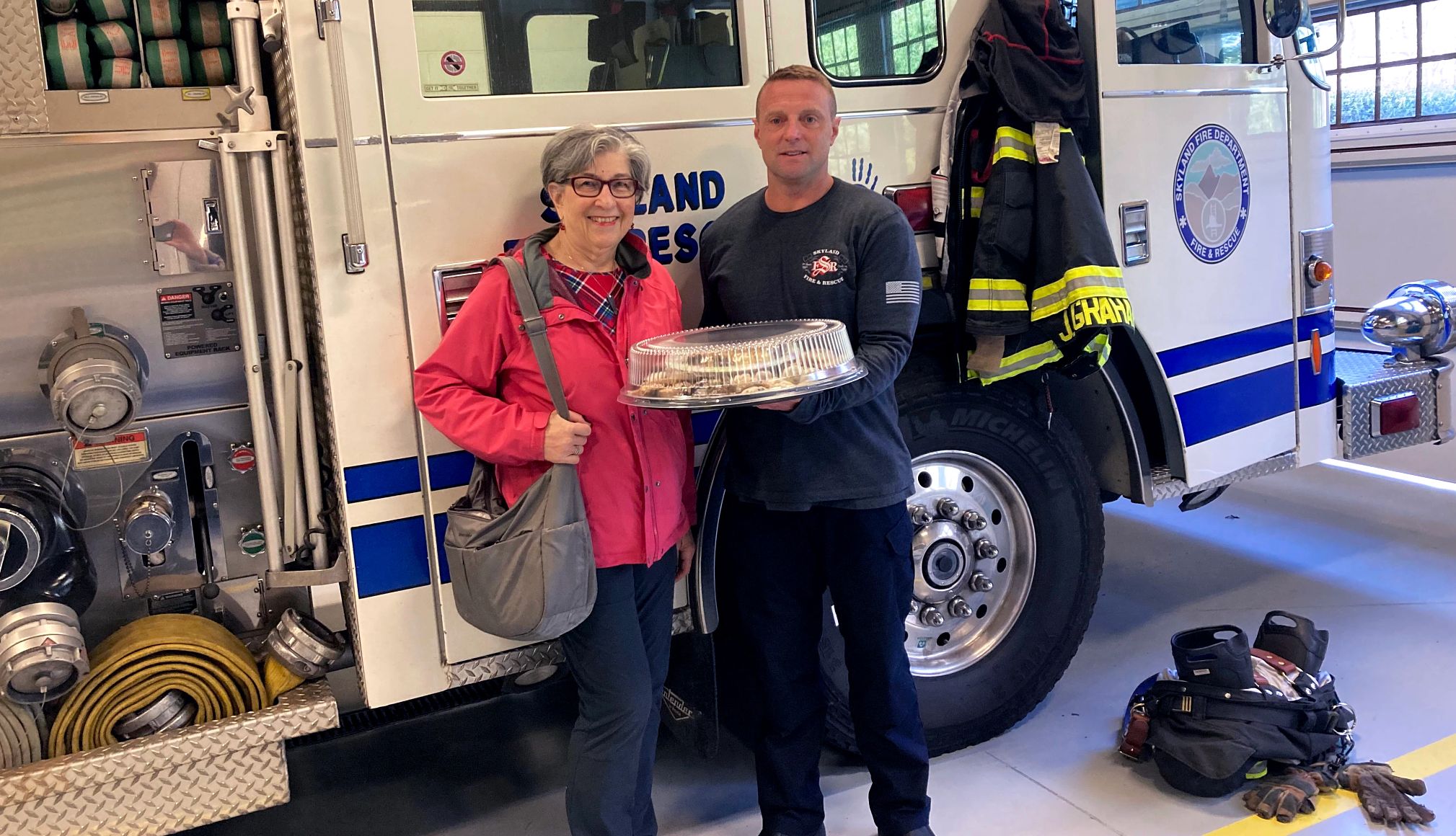 Barbara Beckerman gives extra baked goods to a firefighter
