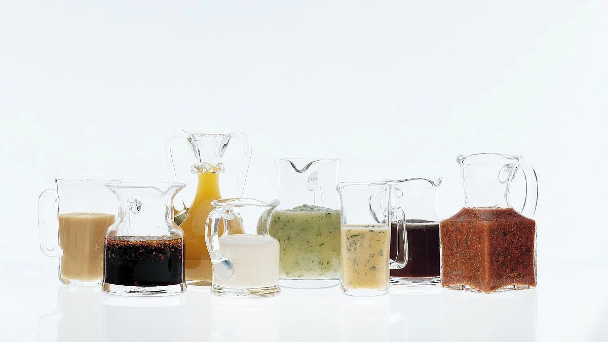 A close-up view of lemon-mint vinaigrette in pitchers