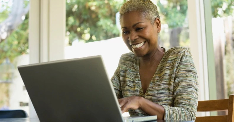 An illustration of a person sitting at a laptop with a video on the screen.