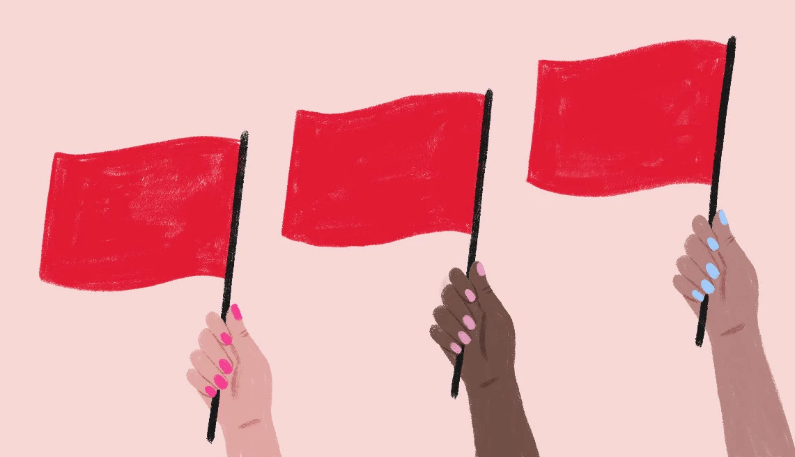 hands hold three red flags on a pink background
