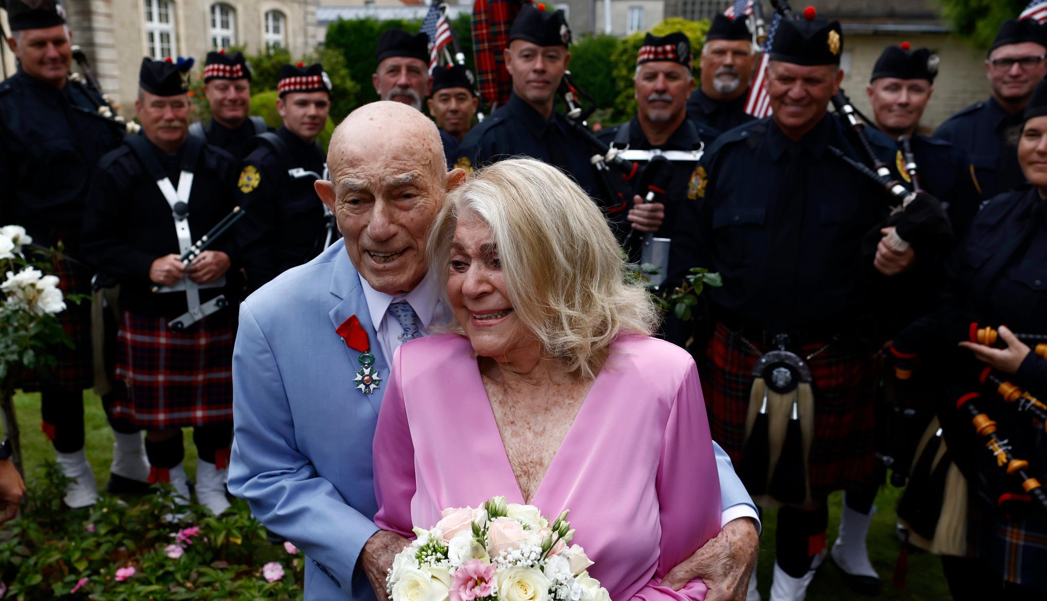 World War II veteran Harold Terens marries Jeanne Swerlin harold terens, in a light blue suit, stands behind jeanne swerlin, holding flowers in a light pink dress. both are smiling during their wedding.