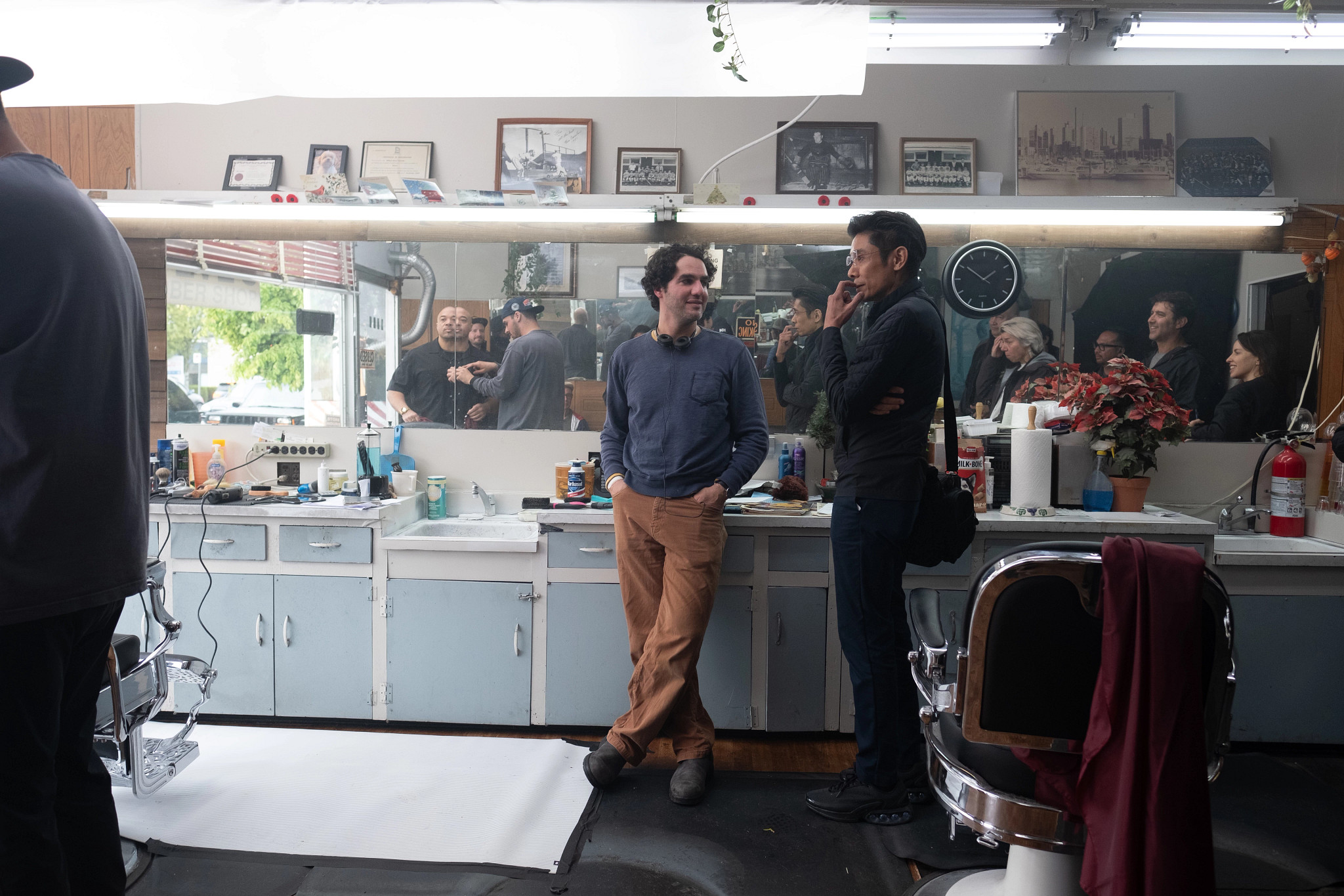 people looking on as a film crew prepares a scene on a movie set