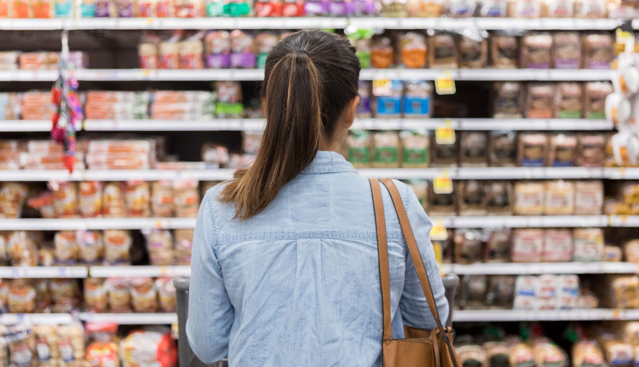 25 Foods to Skip After Age 50 a woman is standing at a store