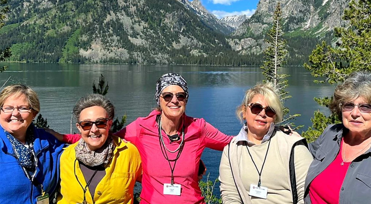 Women in a group in front of a lake